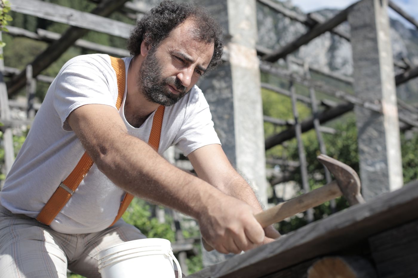 Carpenter hammering a wooden rail outdoors